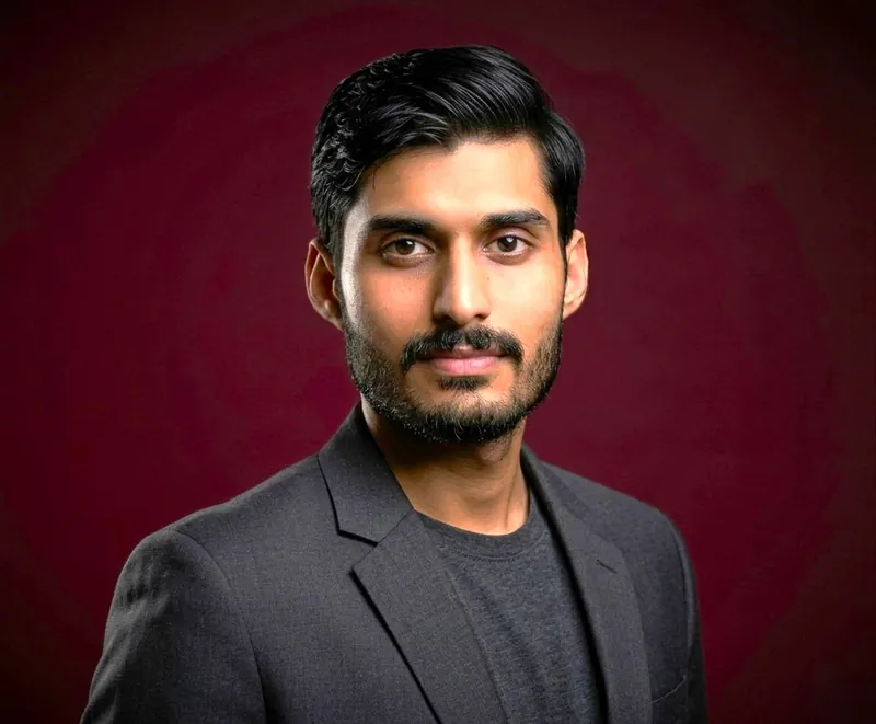 Farhad Nazir، مؤسس برنامج Asaan Optics لمحلات النظارات ومطوّره، بسترة داكنة على خلفية عنابية